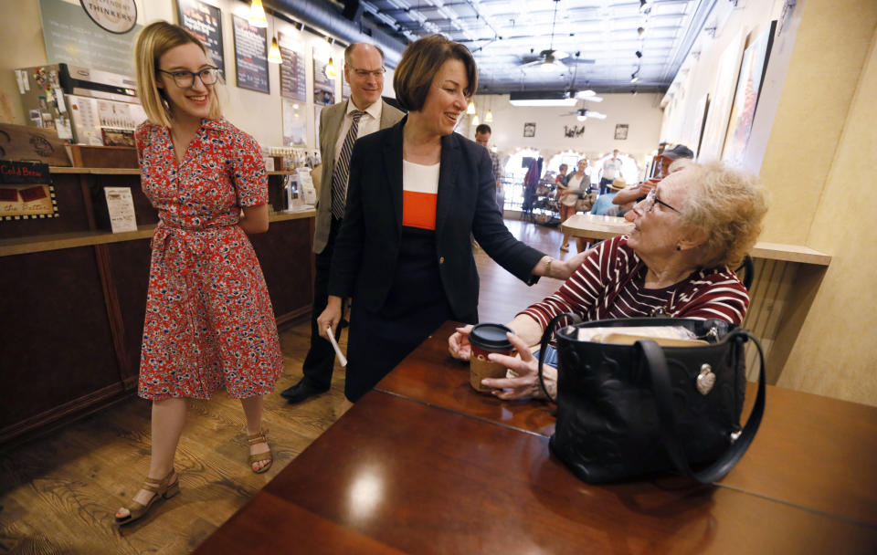 FILE - In this May 25, 2019, file photo, Democratic presidential candidate Sen. Amy Klobuchar, D-Minn., center, and her daughter Abigail, left, talks with Linda Gehrke, of Iowa Falls, right, during a meet and greet at a coffee shop in Iowa Falls, Iowa. (AP Photo/Charlie Neibergall, File)