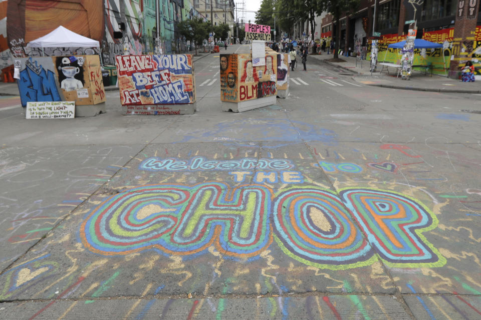 A sign on the street welcomes visitors, Wednesday, June 24, 2020, inside the CHOP (Capitol Hill Occupied Protest) zone in Seattle. The area has been occupied since a police station was largely abandoned after clashes with protesters, but Seattle Mayor Jenny Durkan said Monday that the city would move to wind down the protest zone following several nearby shootings and other incidents that have distracted from changes sought by peaceful protesters opposing racial inequity and police brutality. (AP Photo/Ted S. Warren)