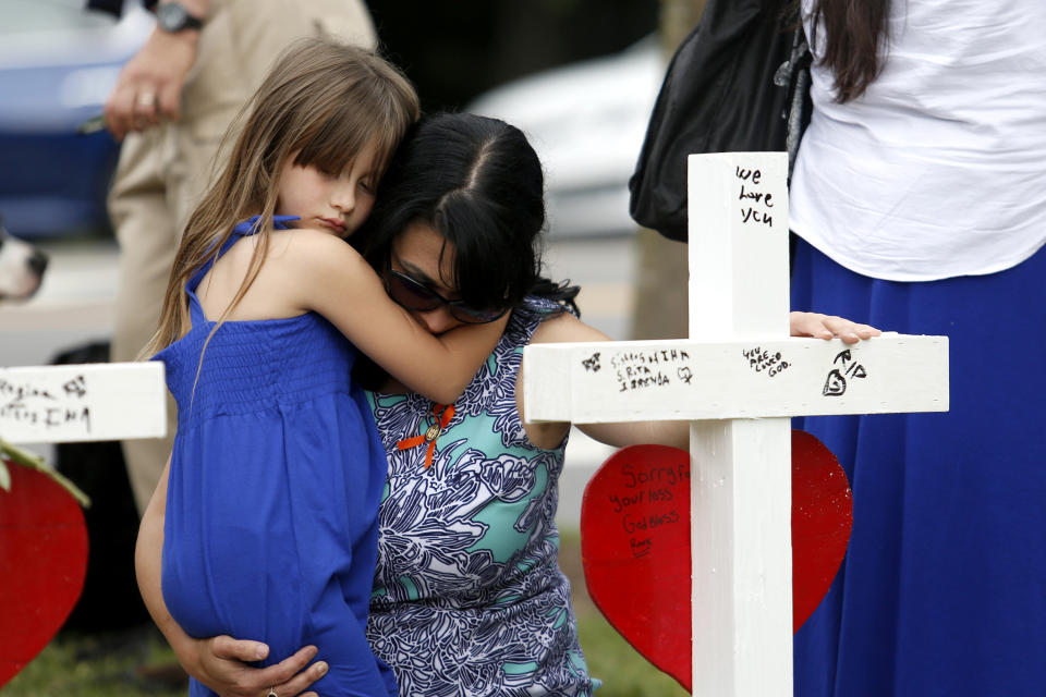Del. Kelly Fowler holds her daughter Sophie, 6, in front of the row of crosses at the memorial located by Building 11 of the Virginia Beach Municipal Center, June 2, 2019, in Virginia Beach, Va. Twelve crosses were placed at the memorial to honor the 12 victims of the mass shooting that took place at the center several days earlier. (Photo: Sarah Holm/The Virginian-Pilot via AP)