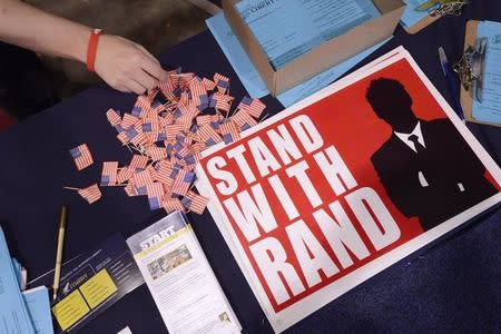 A guest reaches for a flag pin at the Senator Rand Paul (R-KY) booth at the Conservative Political Action Conference (CPAC) in National Harbor, Maryland, February 28, 2015. REUTERS/Mike Theiler/Files