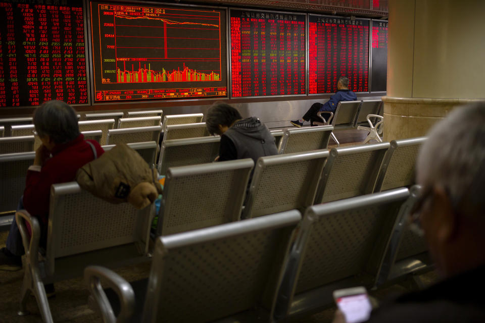 In this Tuesday, Nov. 19, 2019, photo, Chinese investors monitor stock prices at a brokerage house in Beijing. Shares retreated in Asia on Wednesday after Japan reported its worst monthly decline in exports in three years. (AP Photo/Mark Schiefelbein)