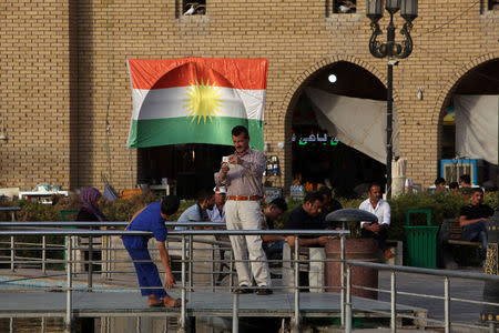 A man takes a photo of his son near the castle market of Erbil, Iraq, August 17, 2017. Picture taken August 17, 2017. REUTERS/Azad Lashkari