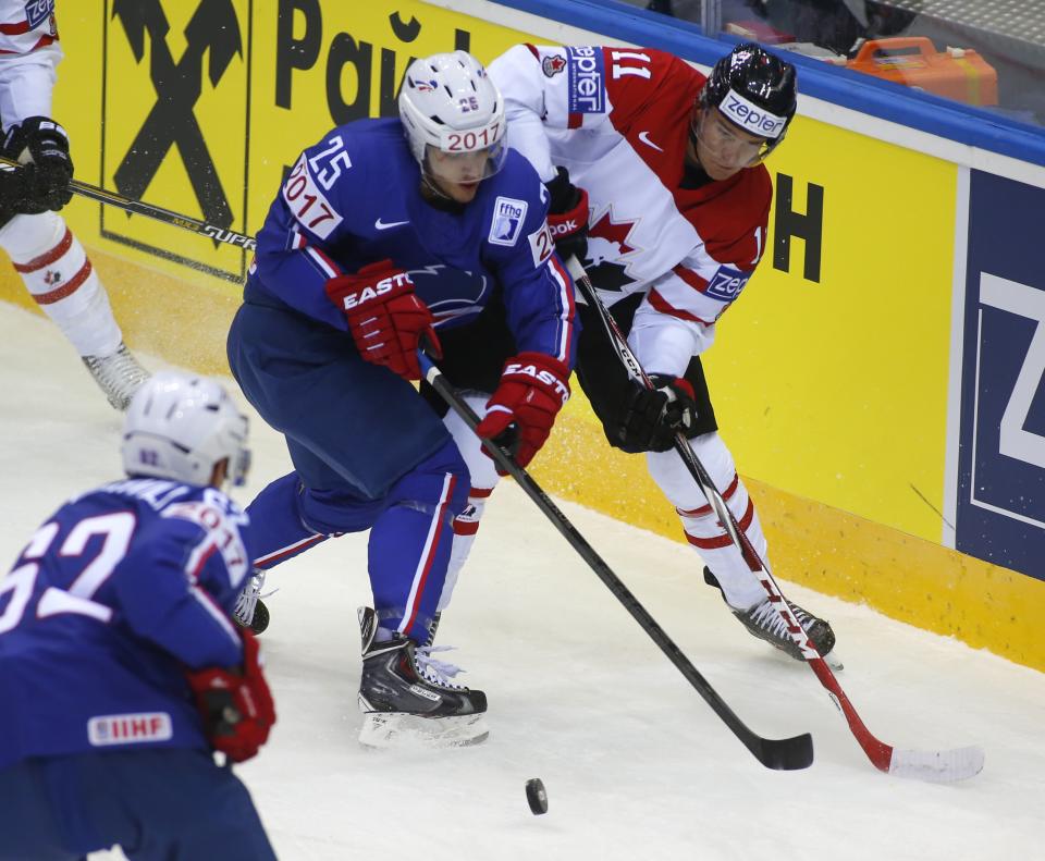 Canada's Jonathan Huberdeau, right, and France's Nicolas Ritz battle for the puck during the Group A preliminary round match between Canada and France at the Ice Hockey World Championship in Minsk, Belarus, Friday, May 9, 2014. (AP Photo/Sergei Grits)