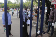An official checks the body temperature of a candidate before appearing for National Eligibility cum Entrance Test ( NEET) at an exam centre in Hyderabad, India, Sunday, Sept. 13, 2020. NEET is for students who wish to study undergraduate medical and dental courses in government or private medical colleges in India. India's coronavirus cases are now the second-highest in the world and only behind the United States. (AP Photo/Mahesh Kumar A.)