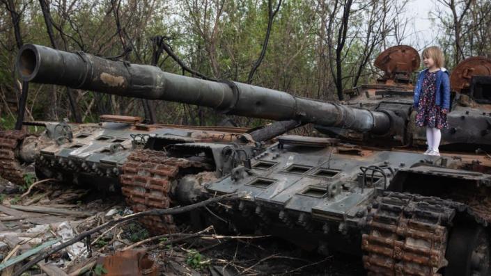 Ni&#xf1;a sobre tanque ruso abandonado y fuera de servicio.