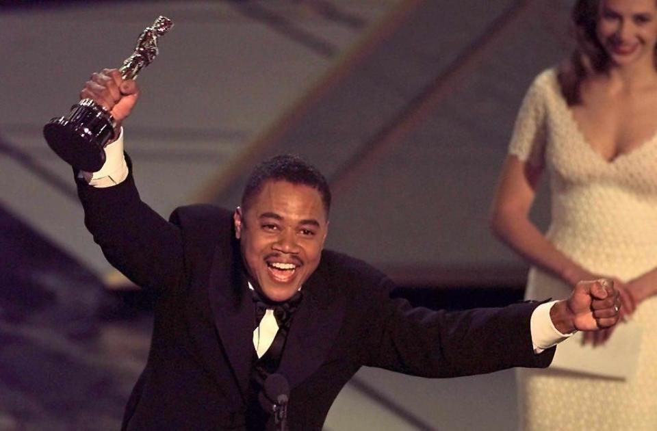 LOS ANGELES, UNITED STATES:  Actor Cuba Gooding, Jr holds up his Oscar after winning the Best Supporting Actor Award for his role in 