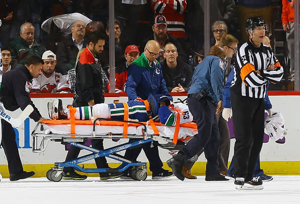 NEWARK, NJ - DECEMBER 06: Philip Larsen #63 of the Vancouver Canucks is taken off the ice on a stretcher after being injured during the game against the New Jersey Devils at Prudential Center on December 6, 2016 in Newark, New Jersey. (Photo by Andy Marlin/NHLI via Getty Images)