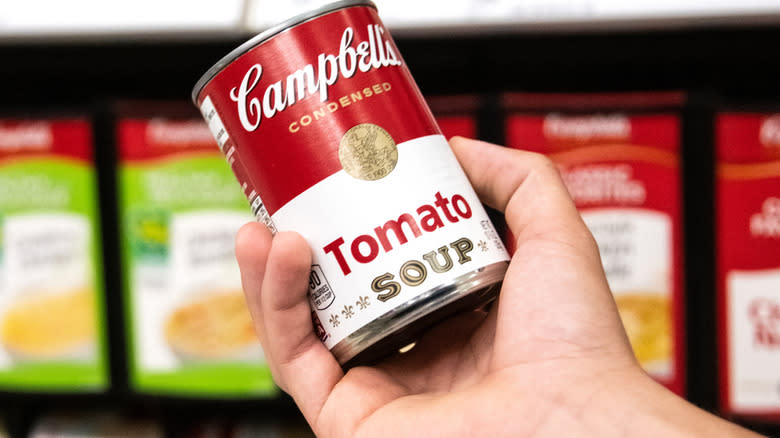 A man holding a can of Tomato soup