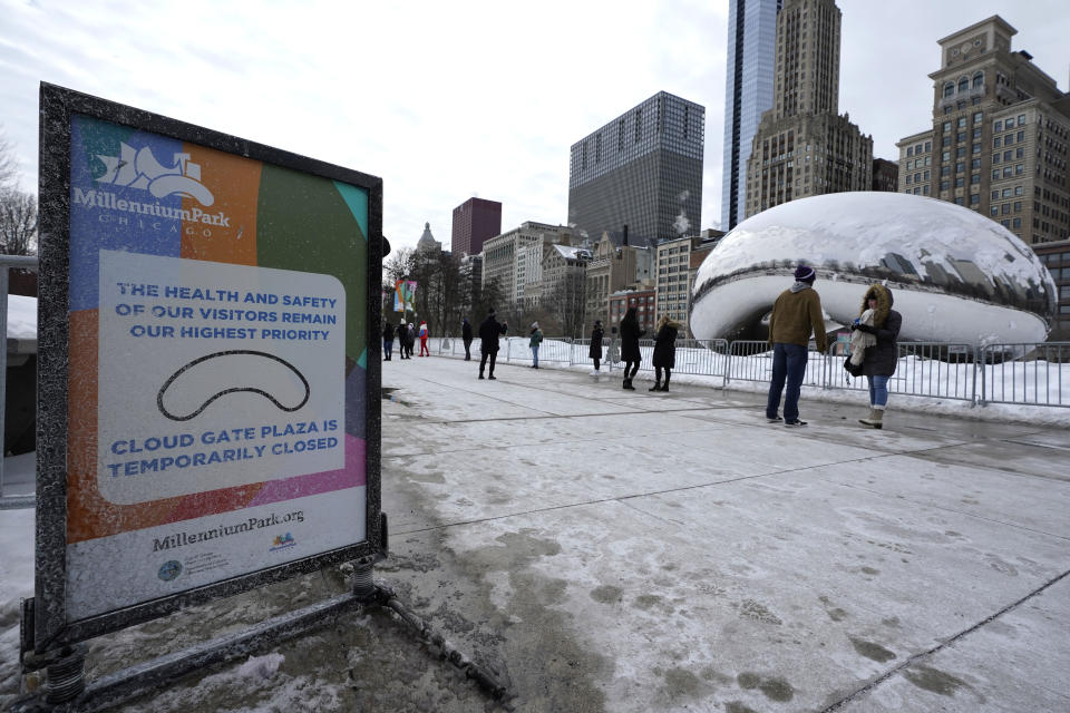 A sign advises that the area immediately around the Cloud Gate sculpture at Millennium Park in Chicago is closed during the coronavirus pandemic, on a cold winter's day Sunday, Feb. 14, 2021. (AP Photo/Nam Y. Huh)