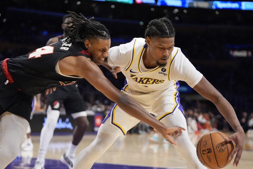 Portland forward Jabari Walker, left, tries to steal the ball away from Lakers forward Cam Reddish at Crypto.com Arena.