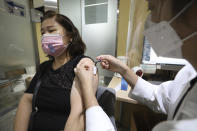 A woman wearing a face mask gets a flu shot at the Korea Association of Health Promotion in Seoul, South Korea, Thursday, Oct. 22, 2020. The steady spread of the coronavirus caused concern in a country that eased its social distancing restrictions just last week to cope with a weak economy. (Hong Hyo-shick/Newsis via AP)
