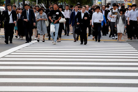 FILE PHOTO: Pedestrians make their way in a business district in Tokyo, Japan May 16, 2018. REUTERS/Kim Kyung-Hoon