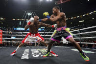 Errol Spence Jr., right, and Yordenis Ugas, from Cuba, trade punches during a welterweight championship boxing match Saturday, April 16, 2022, in Arlington, Texas. (AP Photo/Jeffrey McWhorter)