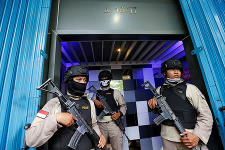 FILE PHOTO: Policemen hold rifles during a police investigation into a men's club after a weekend raid on what authorities described as a "gay spa" in Jakarta, Indonesia, October 9, 2017. REUTERS/Beawiharta/File Photo