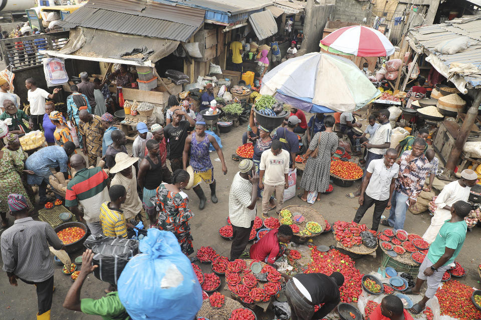 Pedestrians shop for pepper and other food items at the Mile 12 Market in Lagos, Nigeria, Friday, Feb. 16, 2024. Nigerians are facing one of the West African nation's worst economic crises in as many years triggered by a surging inflation rate which follows monetary policies that have dipped the local currency to an all-time low against the dollar, provoking anger and protests across the country. (AP Photo/Mansur Ibrahim)
