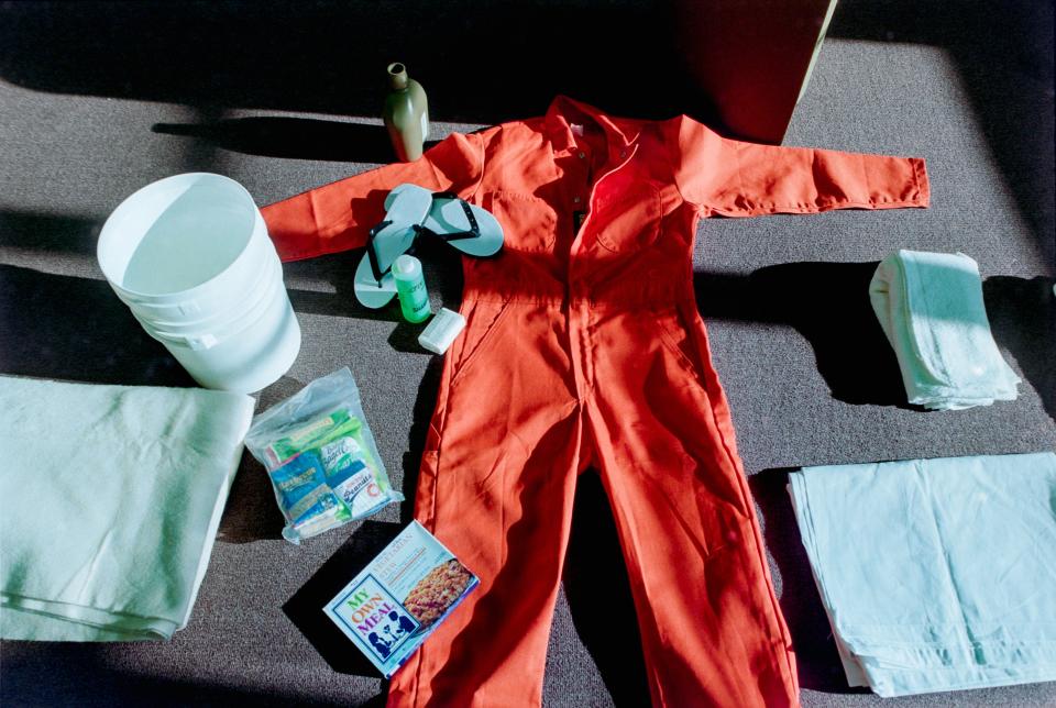 An orange jumpsuit and other items spread out on the floor.