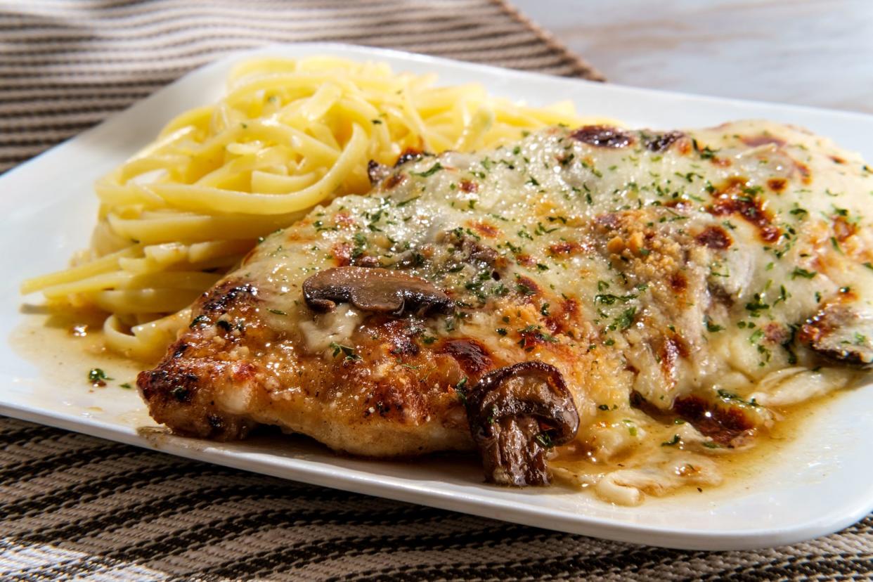 Italian cuisine chicken Lombardy with marsala mushroom gravy and linguine