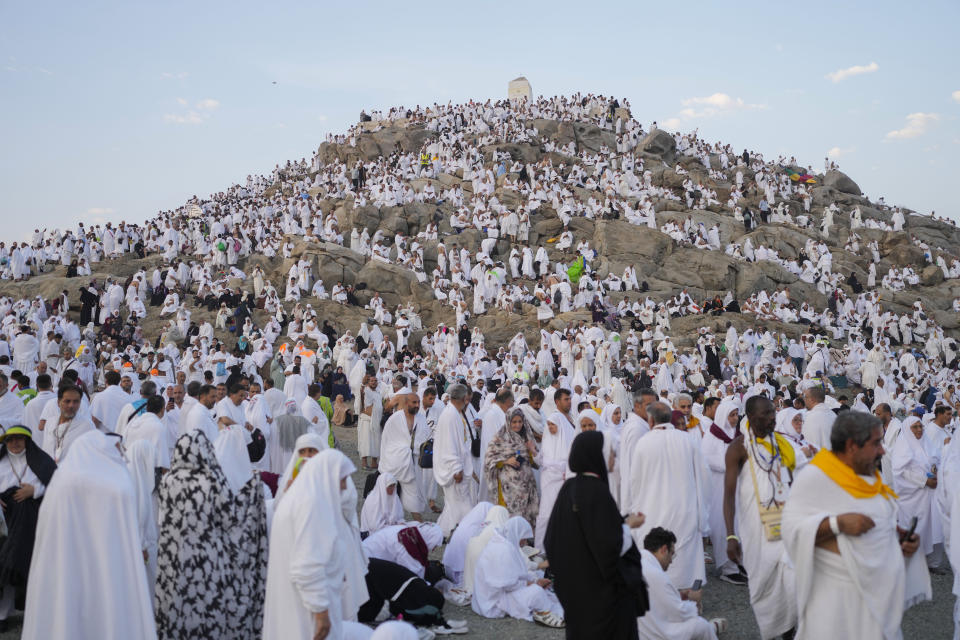 Peregrinos musulmanes se congregan en la cima de una colina rocosa conocida como la montaña de la misericordia, en la llanura de Arafat, durante la peregrinación anual del haj, cerca de la ciudad santa de La Meca, Arabia Saudí, el 15 de junio de 2024. (AP Foto/Rafiq Maqbool)