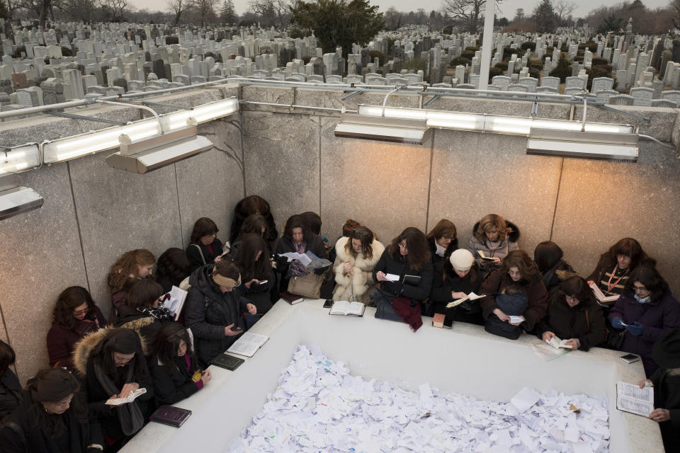 FILE - Chabad Lubavitch women visit the grave sites of Rabbe Menachem Mendel Schneerson and his wife, Rebbetzin Chaya Mushka Schneerson, on the 30th anniversary of her death, Friday, Feb. 9, 2018 in the Queens borough of New York. The rebbe was the spiritual leader of the Lubavitcher hasidic community. (AP Photo/Mark Lennihan, File)