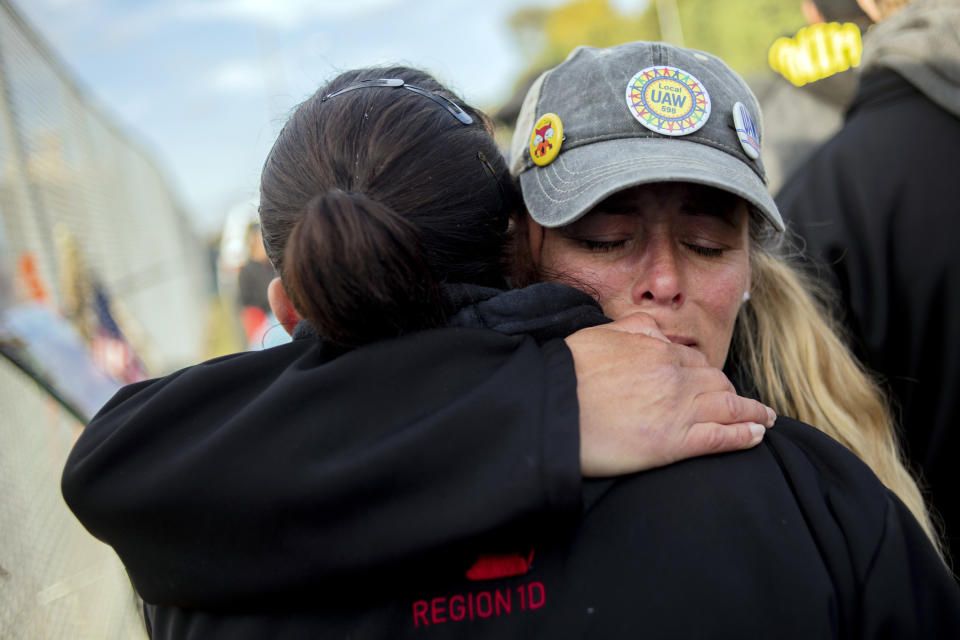 Clio resident Dawn Dekalita, 48, and a 16-year employee at the Flint Assembly Plant, holds a fellow striker as the United Auto Workers strike against General Motors comes to an emotional close outside of the Flint Assembly Plant, Friday, Oct. 25, 2019, in Flint, Mich. Striking General Motors factory workers are putting down their picket signs after approving a new contract that will end a 40-day strike that paralyzed the company's U.S. production. (Jake May/MLive.com/The Flint Journal via AP)