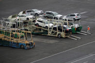 A worker walks beside newly produced cars at Keihin industrial zone in Kawasaki, Japan, September 14, 2016. Picture taken September 14, 2016. REUTERS/Toru Hanai