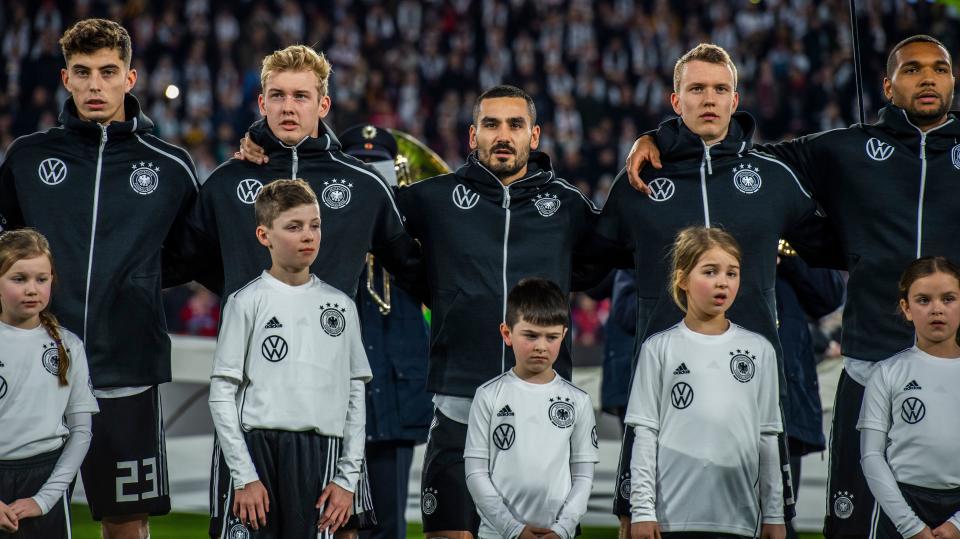 (L-R) Germany's midfielder Kai Havertz, Germany's forward Julian Brandt, Germany's captain Ilkay Gundogan, Germany's defender Lukas Klostermann and Germany's defender Jonathan Tah stand during the anthems prior to the friendly football match Germany v Serbia in Wolfsburg, western Germany on March 20, 2019. (Photo by John MACDOUGALL / AFP) / RESTRICTIONS: ACCORDING TO DFB RULES IMAGE SEQUENCES TO SIMULATE VIDEO IS NOT ALLOWED DURING MATCH TIME. MOBILE (MMS) USE IS NOT ALLOWED DURING AND FOR FURTHER TWO HOURS AFTER THE MATCH. == RESTRICTED TO EDITORIAL USE == FOR MORE INFORMATION CONTACT DFB DIRECTLY AT +49 69 67880 /         (Photo credit should read JOHN MACDOUGALL/AFP/Getty Images)