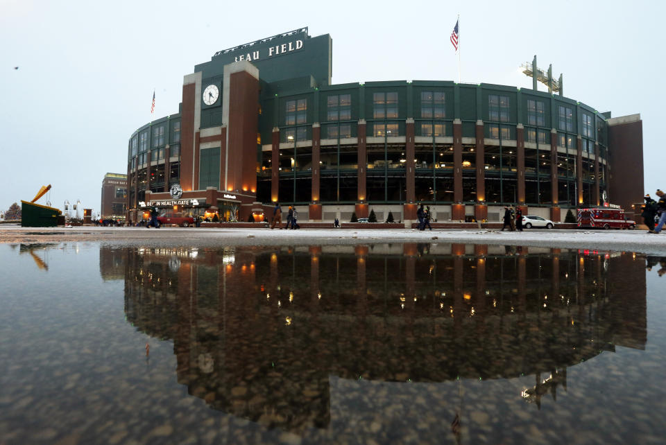 Lambeau Field is seen reflected in a puddle of water before an NFL football game between the Green Bay Packers and the Atlanta Falcons Monday, Dec. 8, 2014, in Green Bay, Wis. (AP Photo/Mike Roemer)