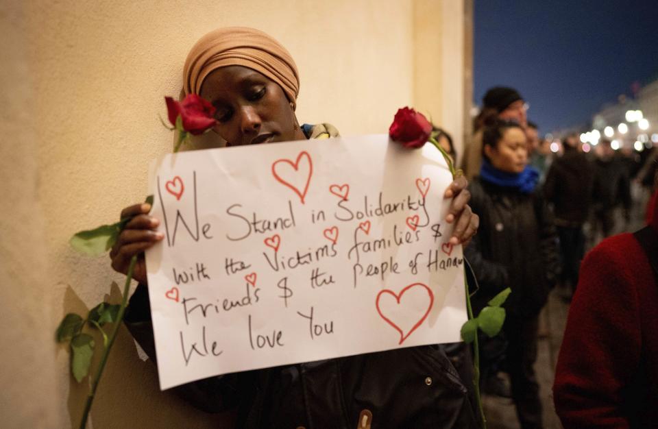 Participants commemorate the people killed in the Hanau shooting at a vigil at the Brandenburg Gate, in Berlin, Thursday Feb. 20. 2020. A 43-year-old German man who posted a manifesto calling for the "complete extermination" of many "races or cultures in our midst" shot and killed several people of foreign background on Wednesday night, most of them Turkish, in an attack on a hookah bar and other sites in a Frankfurt suburb, authorities said Thursday. (Kay Nietfeld/DPA via AP)