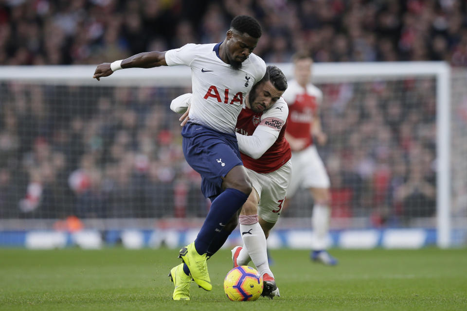 Tottenham's Serge Aurier, left, fights for the ball with Arsenal's Sead Kolasinac during the English Premier League soccer match between Arsenal and Tottenham Hotspur at the Emirates Stadium in London, Sunday Dec. 2, 2018. (AP Photo/Tim Ireland)