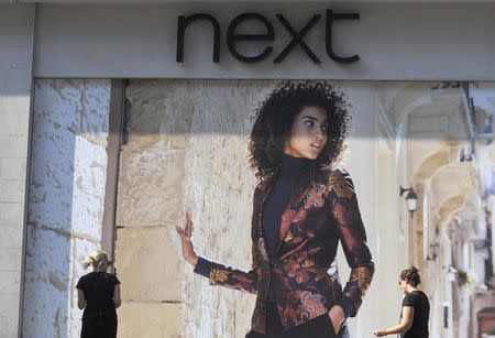 Shoppers pass a branch of Next retail in London, Britain, September 15, 2016. REUTERS/Toby Melville
