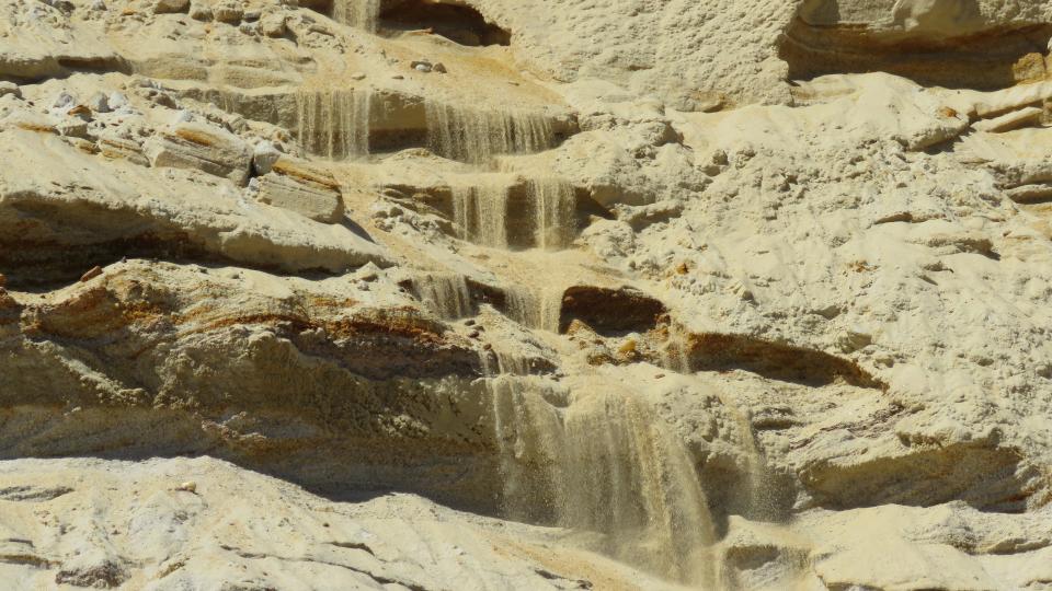 Slow motion erosion: Waterfalls of sand cascade down the sand cliff in Wellfleet.