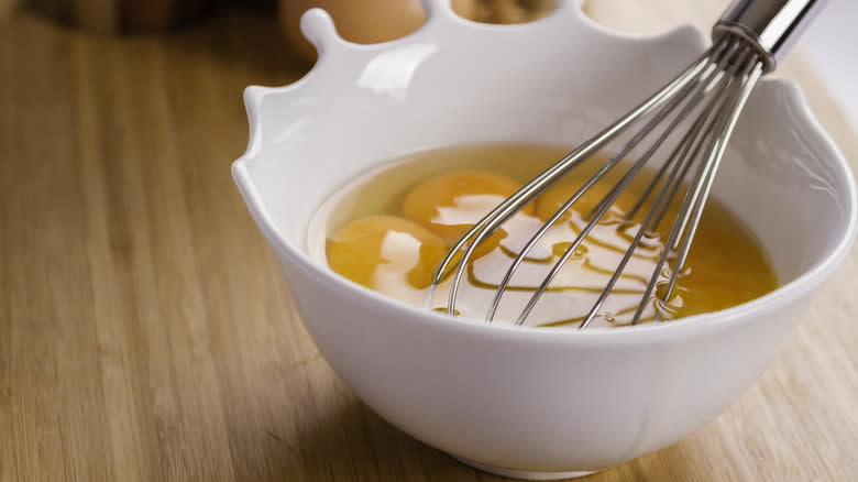 bowl with eggs and whisk