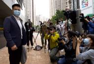 Former legislator and District Council member Gary Fan, left, who was arrested under Hong Kong's national security law poses for photographers before walking in a police station in Hong Kong Sunday, Feb. 28, 2021. Across Hong Kong, dozens of others including former lawmakers and democracy advocates who were arrested in connection with Hong Kong's new National Security Law, went back into a police station Sunday, following a surprise request from police Friday. (AP Photo/Vincent Yu)