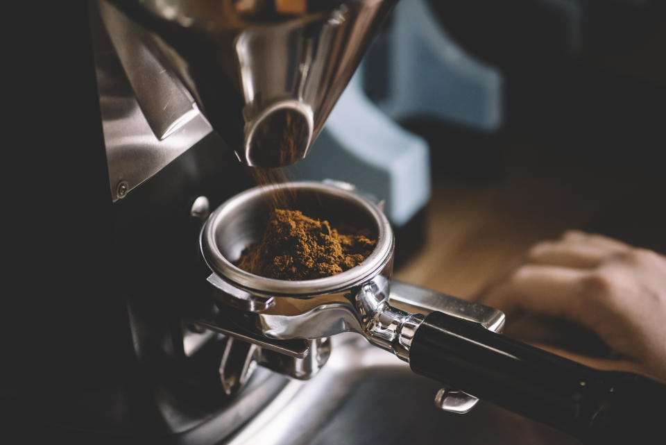 freshly ground coffee beans in a portafilter by the coffee grinderfreshly ground coffee beans in a portafilter by the coffee grinderfreshly ground coffee beans in a portafilter by the coffee grinder