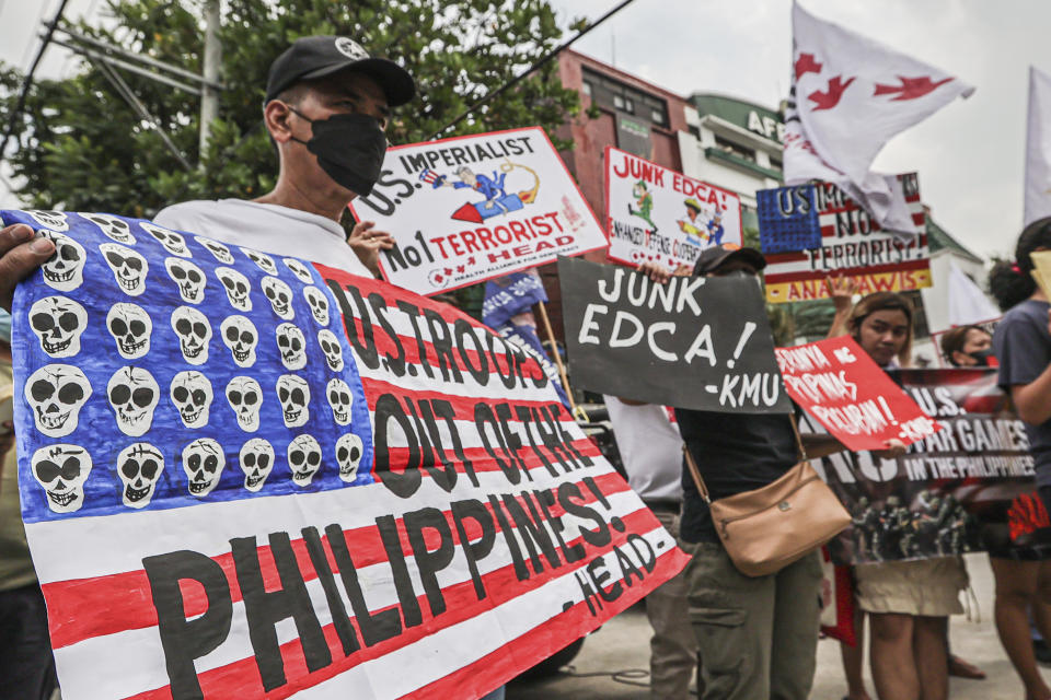 Demonstrators carry placards and shout slogans during a rally in front of Camp Aguinaldo military headquarters in Quezon City, Philippines on Tuesday, April 11, 2023 as they protest against opening ceremonies for the joint military exercise flag called "Balikatan," Tagalog for shoulder-to-shoulder. The United States and the Philippines on Tuesday launch their largest combat exercises in decades that will involve live-fire drills, including a boat-sinking rocket assault in waters across the South China Sea and the Taiwan Strait that will likely inflame China. (AP Photo/Gerard Carreon)