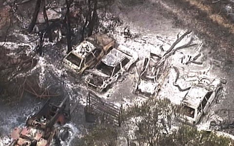 Burned out buildings and vehicles are seen on a scorched landscape in the Deepwater area of Queensland - Credit: AP