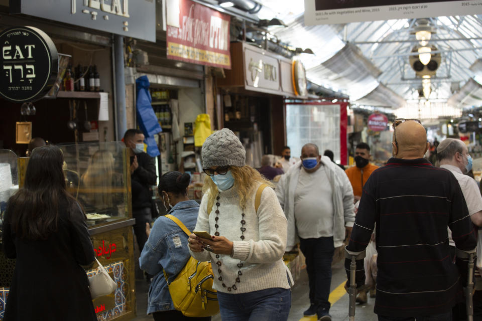 A woman uses her smart phone in the Mahane Yehuda market in Jerusalem, Wednesday, Dec. 23, 2020.In the early days of the pandemic, a panicked Israel began using a mass surveillance tool on its own people, tracking civilians’ mobile phones to halt the spread of the coronavirus. But months later, the tool’s effectiveness is being called into question and critics say its use has come at an immeasurable cost to the country’s democratic principles. (AP Photo/Maya Alleruzzo)