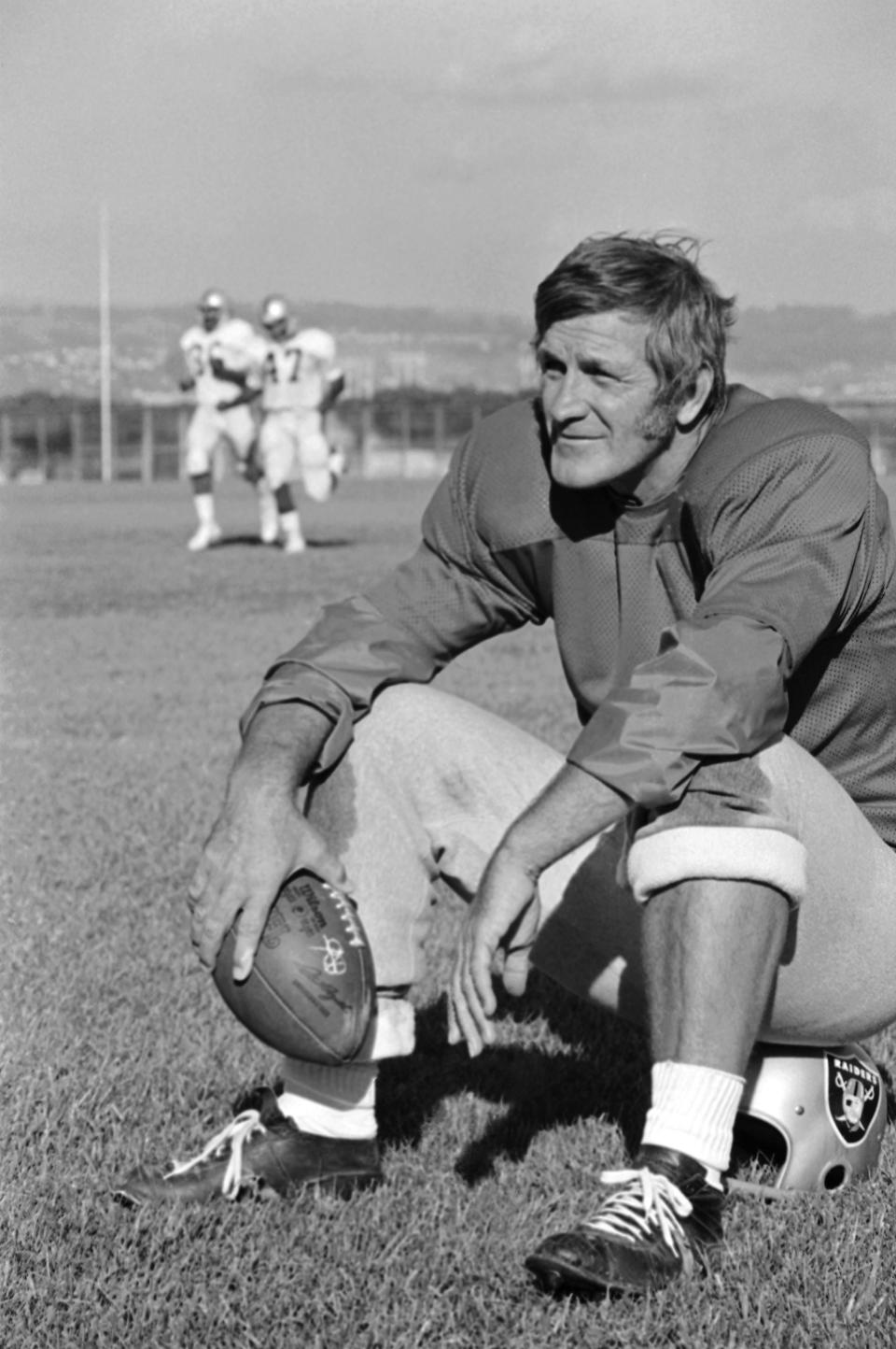 Raiders quarterback and kicker George Blanda relaxes on his helmet during a workout Sept. 20, 1973, in Oakland, California.