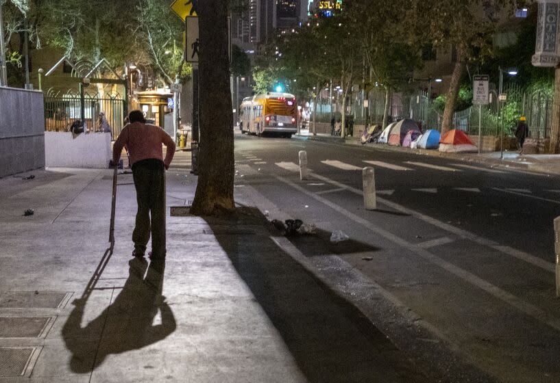 LOS ANGELES, CA - APRIL 22: A man pushed his walker on the sidewalk in the skidrow area in the early morning hours Thursday, April 22, 2021 in Los Angeles, CA. (Francine Orr / Los Angeles Times)