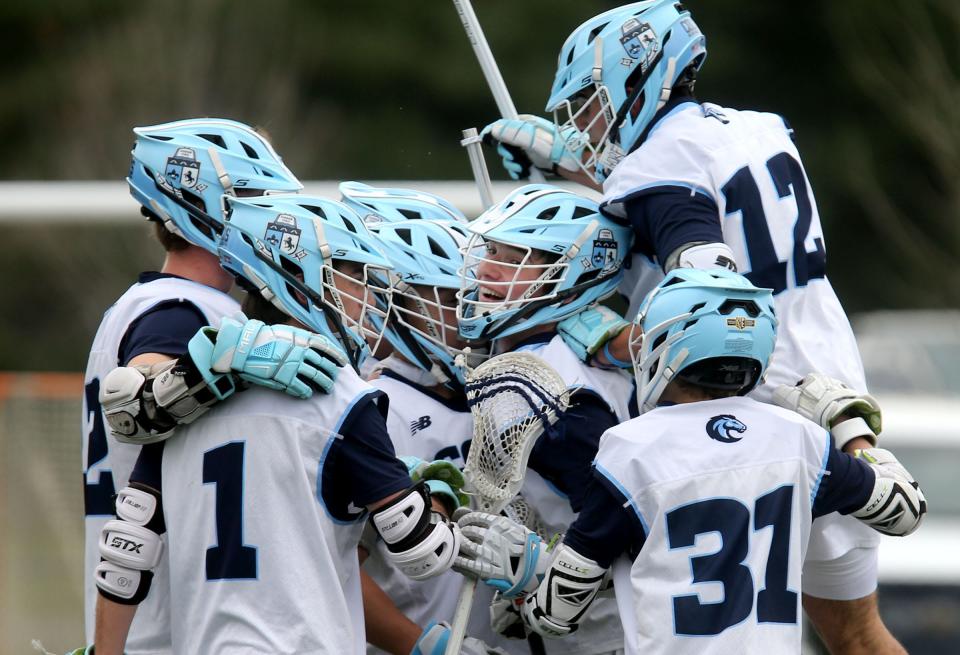 Teammates pile around CBA's Luke Crebs as they celebrate his goal against Wall at home Wednesday, April 10, 2024.