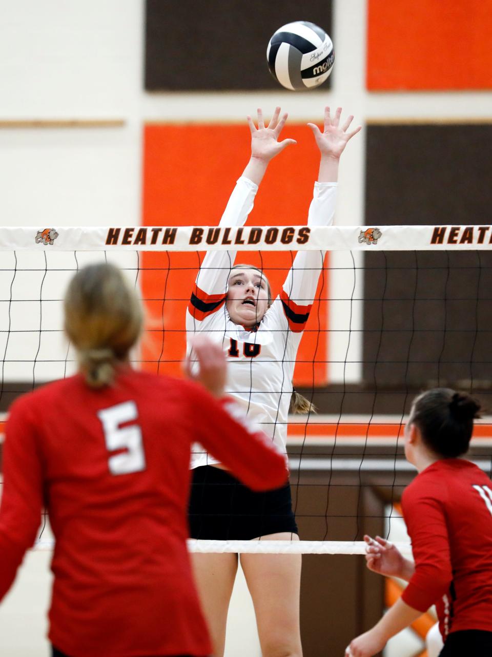 Abby Wilson goes up for a block during New Lexington's 20-25, 21-25, 25-15, 22-25 loss to Belmont Union Local in a Division II regional final on Saturday at Heath High School. New Lex wrapped up a 22-6 season that included their first regional runner-up finish in school history and first district title since 1983.