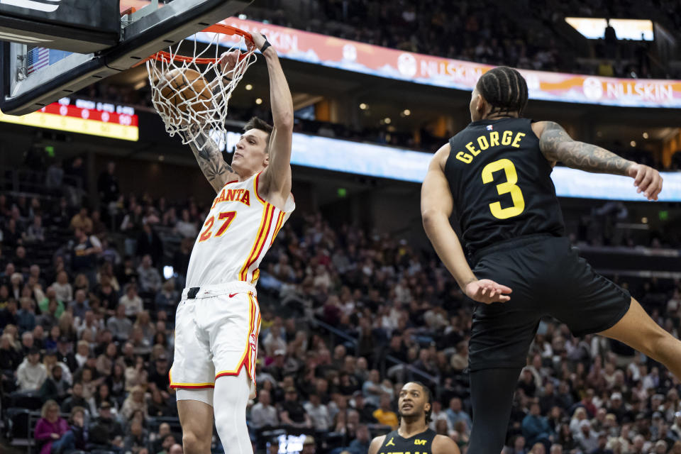 Atlanta Hawks guard Vit Krejci (27) dunks as Utah Jazz guard Keyonte George (3) looks on during the first half of an NBA basketball game, Friday, March 15, 2024, in Salt Lake City. (AP Photo/Spenser Heaps)