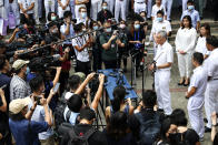 People's Action Party Secretary-General and Singaporean Prime Minister Lee Hsien Loong, right, fields questions from the media at a nomination center ahead of the general election in Singapore, Tuesday, June 30, 2020. Campaigning began Tuesday for Singapore's general elections, with the opposition hoping to dent the ruling party's supermajority in parliament with support from Prime Minister Lee's estranged younger brother. (AP Photo/Yong Teck Lim)