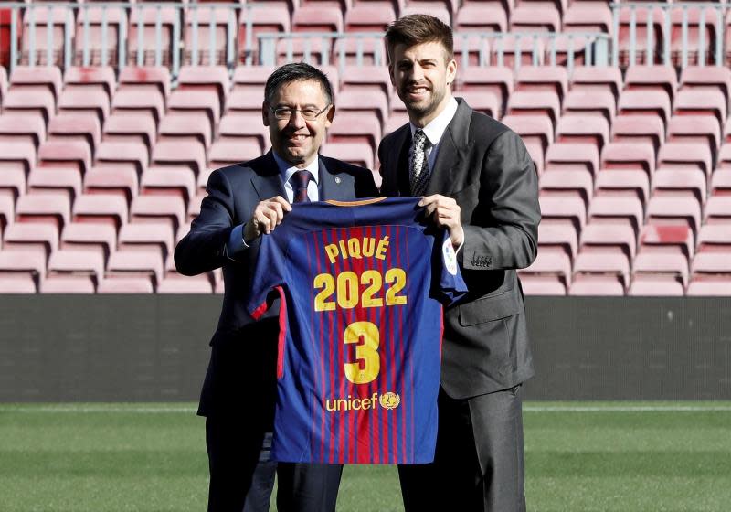 El defensa central del FC Barcelona Gerard Piqué, posa con el presidente del club Josep María Bartomeu, tras firmar su ampliación de contrato con el club azulgrana, en el que permanecerá cuatro temporadas mas. / Foto: EFE