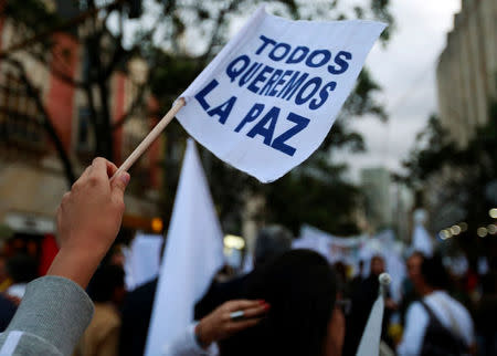 A supporter rallying for the nation’s new peace agreement with FARC holds a banner that reads "We all want peace" during a march in Bogota, Colombia, November 15, 2016. REUTERS/John Vizcaino