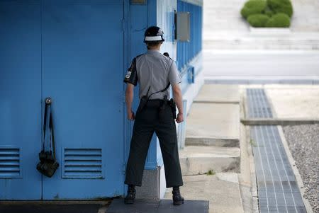 A South Korean soldier stands guard next to a pair of binoculars and belongings hung on the doorknob of the United Nations Command Military Armistice Commission Conference Building at the truce village of Panmunjom, South Korea, July 22, 2015. REUTERS/Kim Hong-Ji