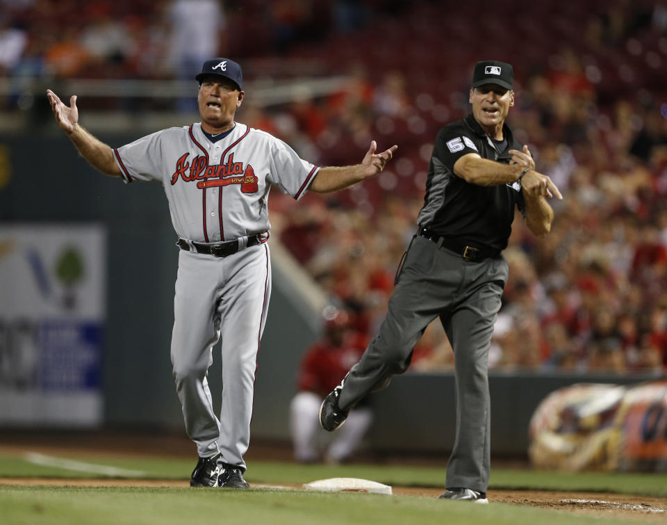 FILE - Atlanta Braves interim Manager Brian Snitker, left, reacts as he is ejected by umpire Angel Hernandez (55) during the tenth inning of a baseball game, July 19, 2016, in Cincinnati. Longtime umpire Hernández, who unsuccessfully sued Major League Baseball for racial discrimination, is retiring immediately, announced Monday, May 27, 2024. (AP Photo/Gary Landers, File)