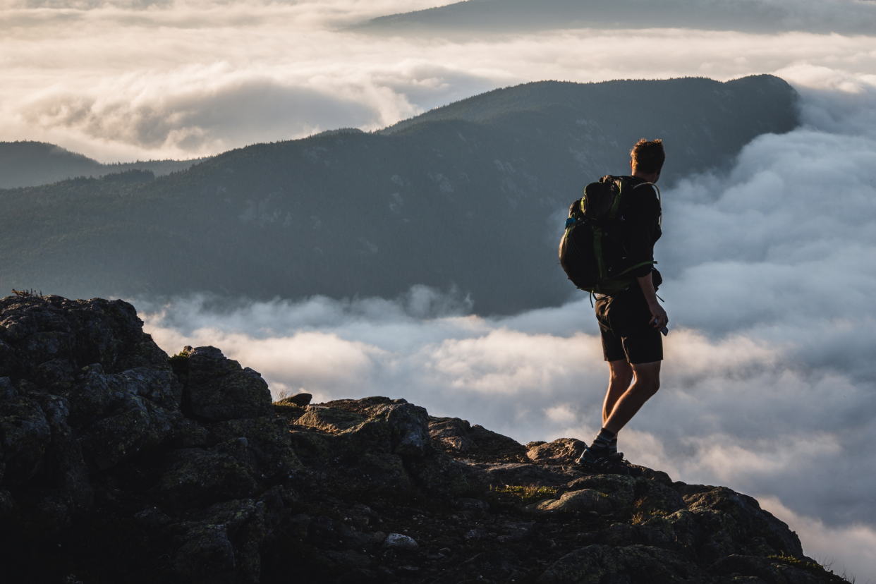 Male Hiker on Summit Gazes at Mountains Rising Above the Clouds, Carrabassett Valley, Maine