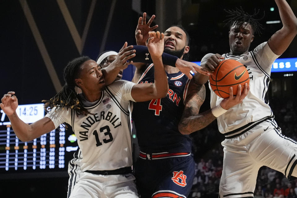 Auburn forward Johni Broome (4) and Vanderbilt guard Malik Presley (13), forward Ven-Allen Lubin, second from left, and forward JaQualon Roberts, right, vie for the ball during the first half of an NCAA college basketball game Wednesday, Jan. 17, 2024 in Nashville, Tenn. (AP Photo/George Walker IV)