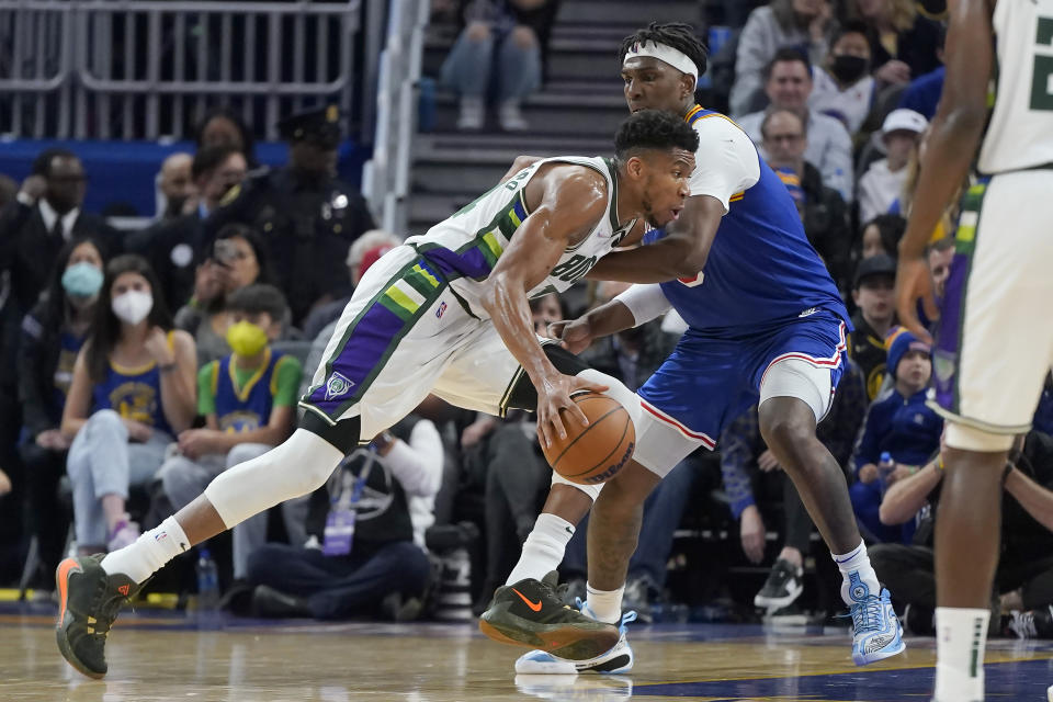 Milwaukee Bucks forward Giannis Antetokounmpo, left, drives to the basket against Golden State Warriors center Kevon Looney during the first half of an NBA basketball game in San Francisco, Saturday, March 12, 2022. (AP Photo/Jeff Chiu)